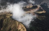 Aerial view of Batur volcano caldera in Bali. Volcanic black texture and crater rim, view from above, drone shot